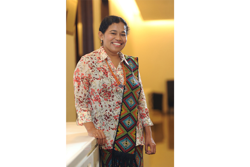 A woman wearing traditional clothing smiling